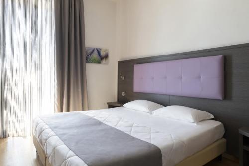 a bedroom with a large bed and a large window at Hotel Settentrionale Esplanade in Montecatini Terme