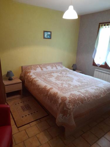 a bedroom with a bed with a white comforter at la chaume in Laugère