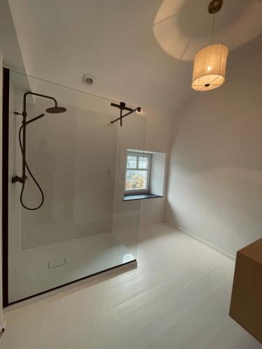 um quarto branco com um chuveiro e uma janela em L'Officine - Résidence Le Cercle em Marche-en-Famenne