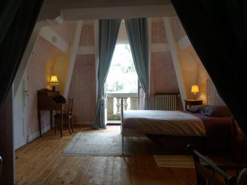 ein Schlafzimmer mit einem Bett und einem großen Fenster in der Unterkunft Le Manoir in Tarare