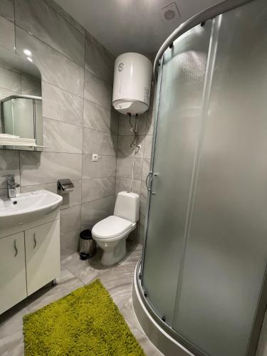 ein Bad mit einer Dusche, einem WC und einem Waschbecken in der Unterkunft Готель ТІК Копичинці in Sukhostav