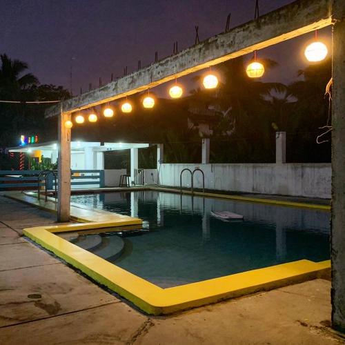 a swimming pool at night with lights above it at Lotus Sun & Waves Beach Resort in Baler