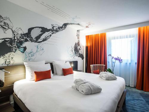 a hotel room with two beds with towels on them at Novotel Paris Les Halles in Paris