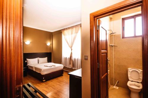 MbuguniにあるPanone Hotel Mereraniのベッドルーム1室(ベッド1台付)、バスルーム(トイレ付)