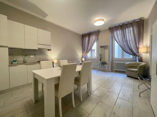 una cucina e una sala da pranzo con tavolo e sedie bianchi di Sant'Anna apartments a Firenze