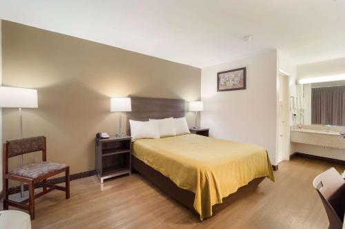 a hotel room with a bed and a chair at Econo Lodge in Goose Creek