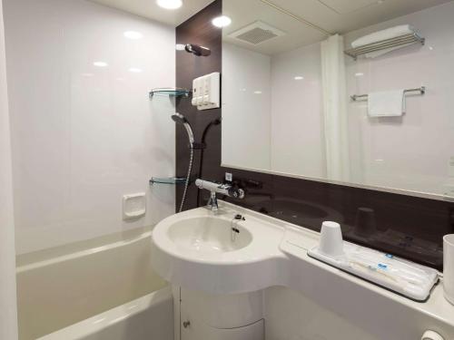 a white bathroom with a sink and a mirror at Comfort Hotel Osaka Shinsaibashi in Osaka