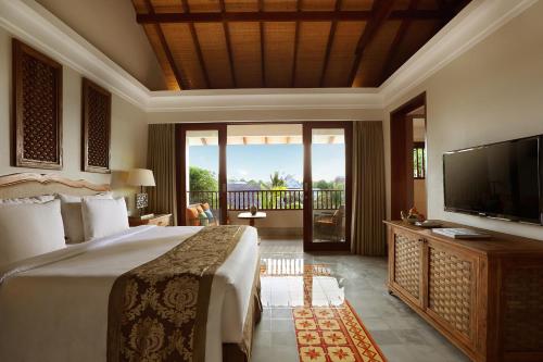 a hotel room with a bed and a tv at Sudamala Resort, Sanur, Bali in Sanur