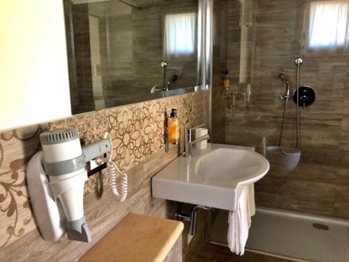 a bathroom with a white sink and a shower at Inghirios Wellness Country Resort in Santa Maria la Palma