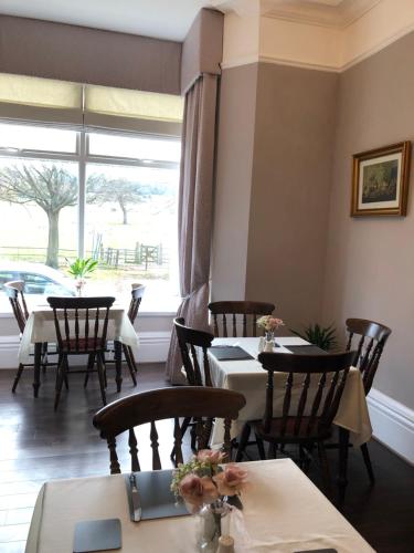 a dining room with tables and chairs and a window at The Old Lodge Guest House in Lincoln