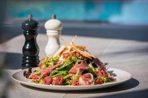 a plate of food with a salad on a table at Riviera Boutique Hotel in Stalida
