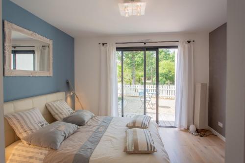 1 dormitorio con 1 cama grande y paredes azules en Dune et Coquelicot, en Gaillan-en-Médoc