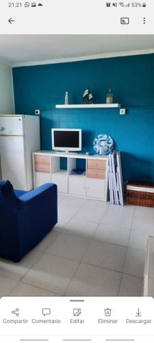 sala de estar con pared azul y TV en Apartamento en San Juan de L'arena en San Juan de la Arena