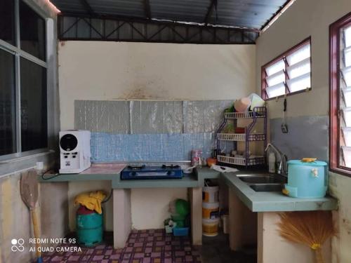 a kitchen with a sink and a counter top at Munir Homestay in Kampung Gurun