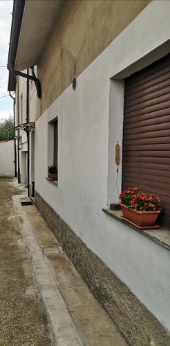 a building with a garage door and flowers in a window at Bilocale Francesca in Erba