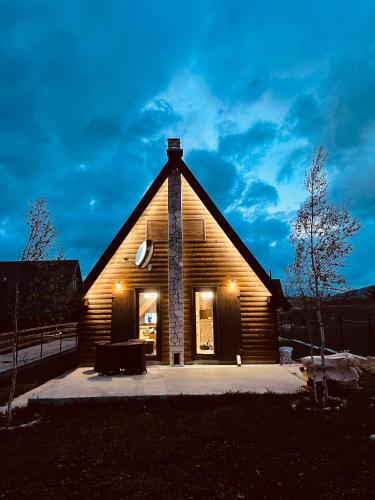a large wooden house with a pitched roof at night at Guest House LENA in Žabljak