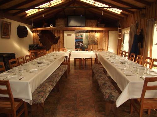 a long table with white tables and chairs in a room at Hostal & Cabañas Don Juan in Villarrica