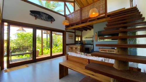 a living room with a wooden bench in a house at Taipu Loft - Península de Maraú in Marau