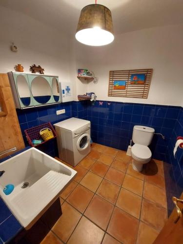 ein blau gefliestes Bad mit WC und Waschbecken in der Unterkunft Casa Rural El Callejo in Hinojosa de Duero