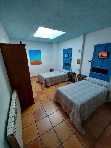 Casa Rural El Callejo في Hinojosa de Duero: سريرين في غرفة ذات أبواب زرقاء