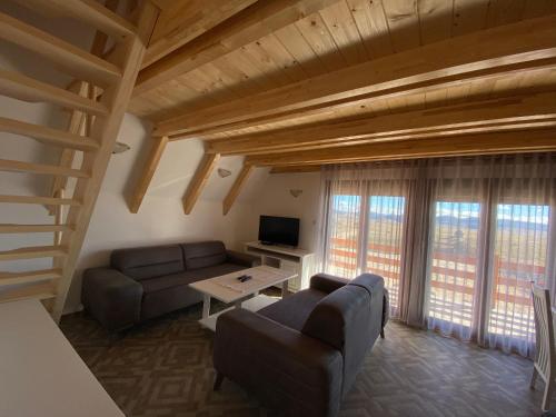 ein Wohnzimmer mit einem Sofa und einem Tisch in der Unterkunft HILL VIEW Chalets in Žabljak