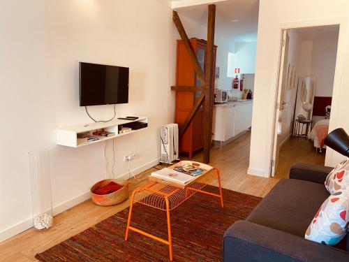 ein Wohnzimmer mit einem Sofa und einem Tisch in der Unterkunft Enjoy Casa dos Corvos Apartment in Lissabon