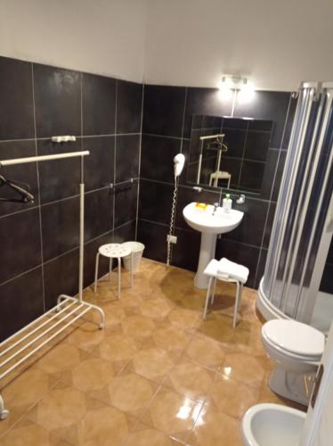 een badkamer met een wastafel, een toilet en een spiegel bij B&B Toscana in Pisa