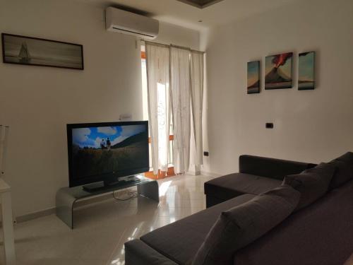 een woonkamer met een bank en een flatscreen-tv bij La Casa di Giù in Pozzuoli