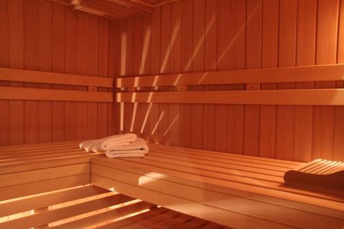 a wooden sauna with two towels sitting on the shelf at Hotel am Schlosspark Zum Kurfürst in Oberschleißheim