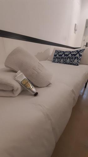 um termómetro sentado em cima de uma cama branca em Hostal Hom Museo em Sevilha