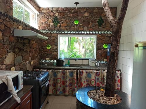 a kitchen with a tree in the middle of it at CASA DA MATA descanso e sossego na natureza in Ibicoara