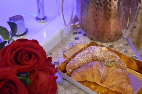 a table with a plate of bread and a rose at SINFONIE PUGLIESI LUXURY ROOM in Turi