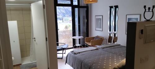 a bedroom with a bed and a chair and a window at Casa de Isora Private apartments in Garachico