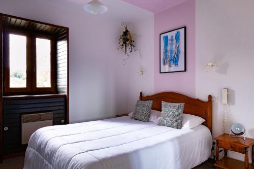 sypialnia z dużym białym łóżkiem i oknem w obiekcie Hôtel le Cantou 354 w mieście Loubressac