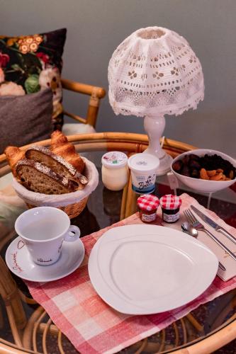 una mesa con un plato de pan y una lámpara en Hôtel le Cantou 354, en Loubressac