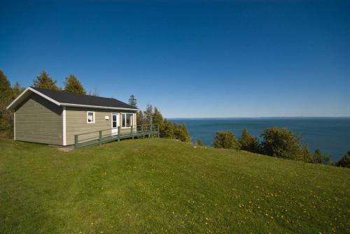 a small house on top of a grassy hill at Domaine Frais Air in La Malbaie