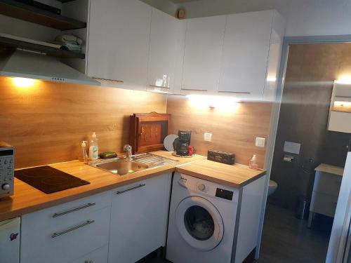 cocina con lavadora y fregadero en Studio moderne classe 2 dans marina proche mer et etang - lit wifi fibre et parking privé, en Sète