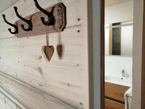 a bathroom with a wooden wall with a heart on it at Au charmant chablis in Champagnole