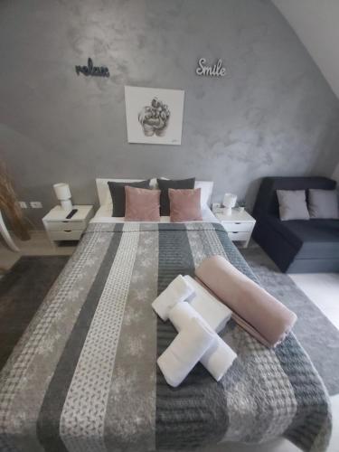 a bedroom with a large bed and a blue couch at VonAmor Rooms in Novi Sad