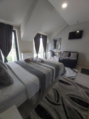 a bedroom with a large bed and a couch at VonAmor Rooms in Novi Sad