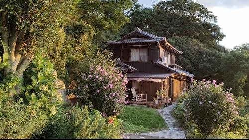 a small wooden house with a chair in a garden at AKUA inn in Awaji