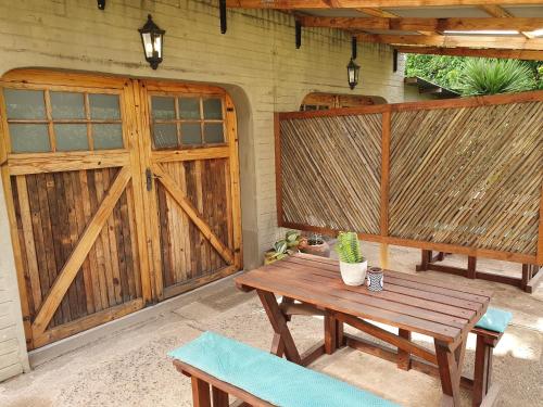 a patio with a wooden gate and a wooden table and bench at Rustique in Graskop
