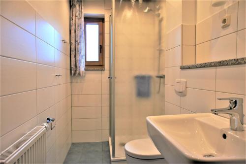 a bathroom with a sink and a toilet and a window at Ferienwohnungen Gaebert in Kellenhusen