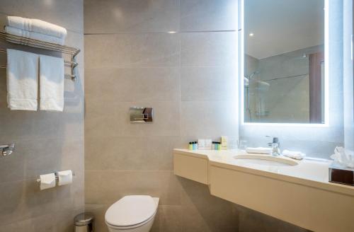 a bathroom with a sink and a toilet and a mirror at Marine Hotel in Sutton