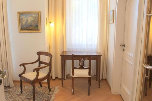 a table and chairs in a room with a window at Barony Le Pergole holiday apartments Lugano in Lugano
