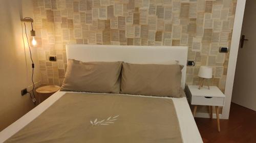 a bed with a white headboard in a bedroom at Glicine & more Forlì in Forlì