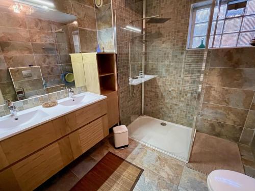 une salle de bain avec une baignoire, un lavabo et une douche dans l'établissement Very comfortable house steps from the beach with garden and terrace, à Hourtin