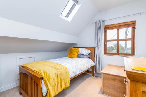 1 dormitorio con cama y ventana en The Pigsty - 3 Bedroom Barn Conversion en Coventry