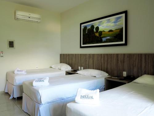 Un pat sau paturi într-o cameră la Imperial Palace - Hotel & Eventos