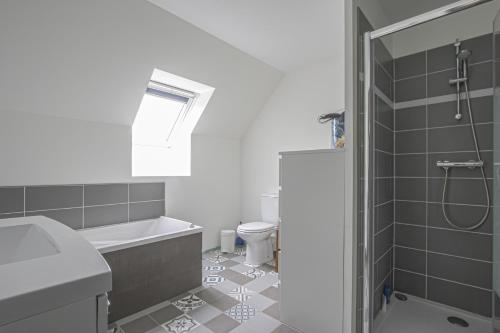 Un baño con bañera, lavabo e inodoro. en La maison des marronniers, en Bayeux